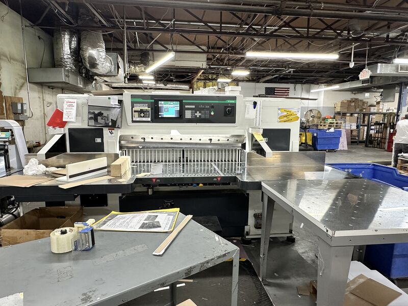 Computerized programmable guillotine cutter with a stack of trimmed sheets