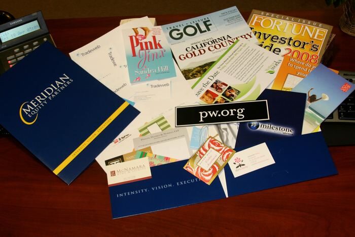 A spread of printed folders, brochures, business cards and mailers produced by Nova Printing